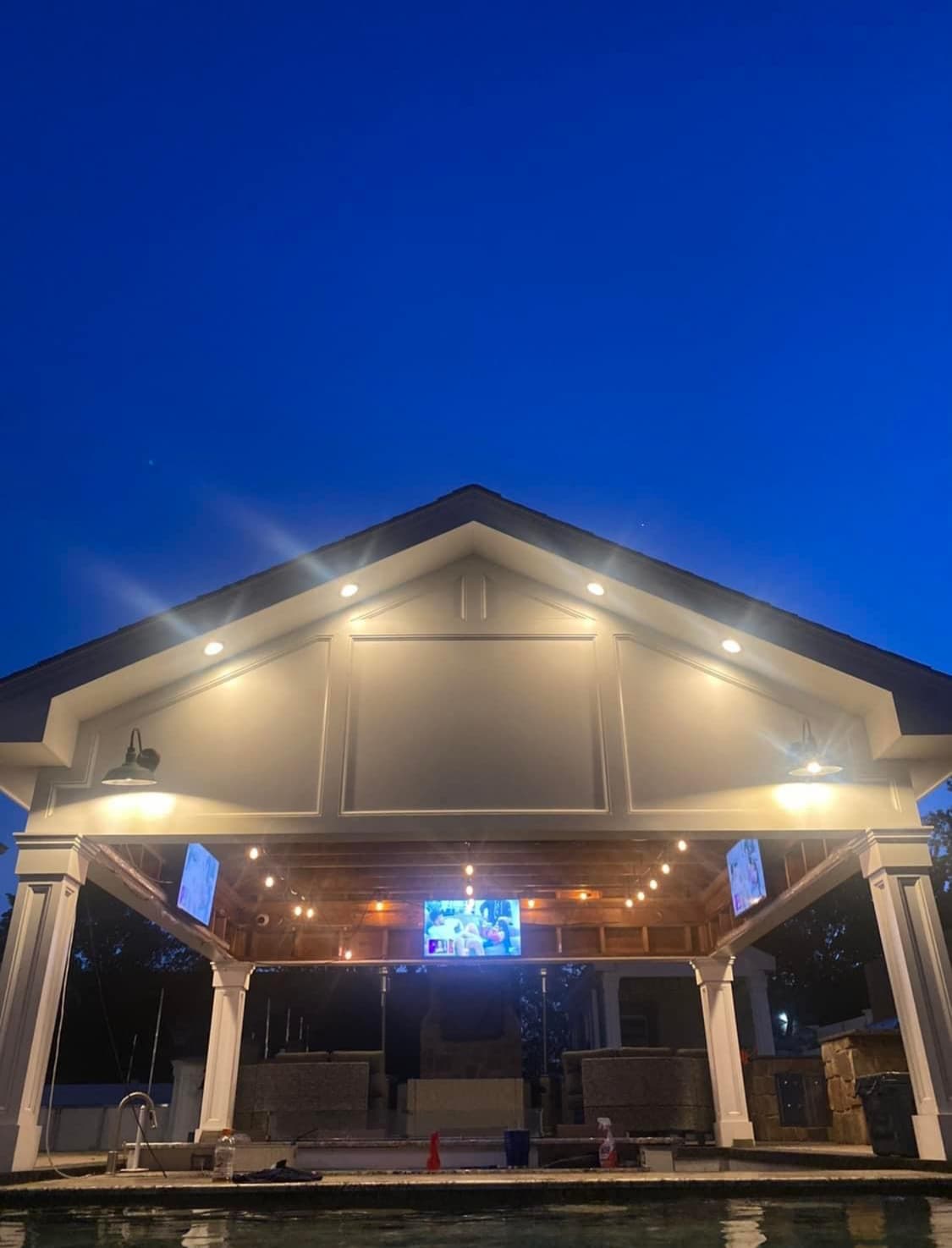 Covered outdoor living room with integrated lighting and media capability.