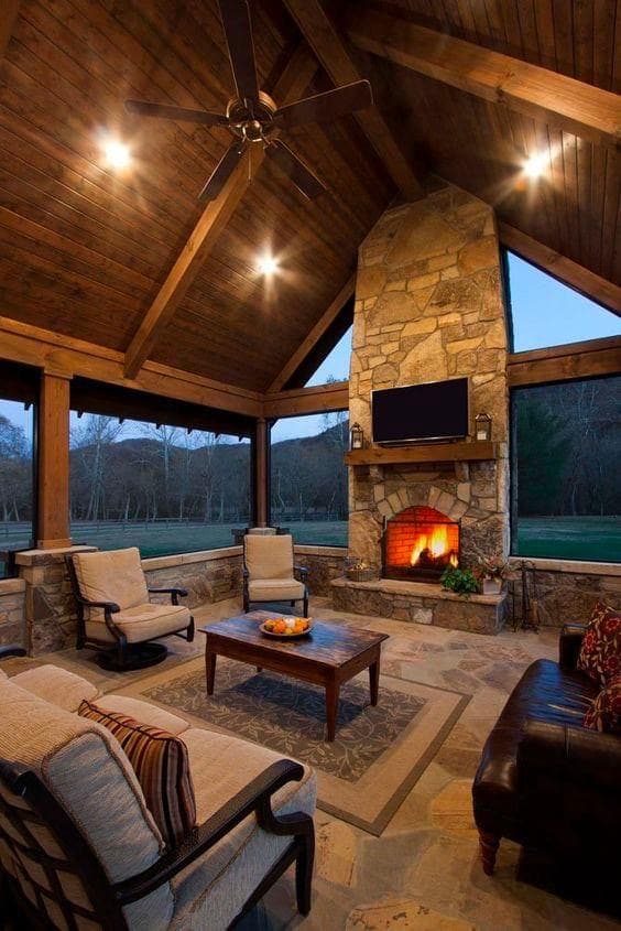 Custom outdoor living area with pool, fire feature, and kitchen at dusk.