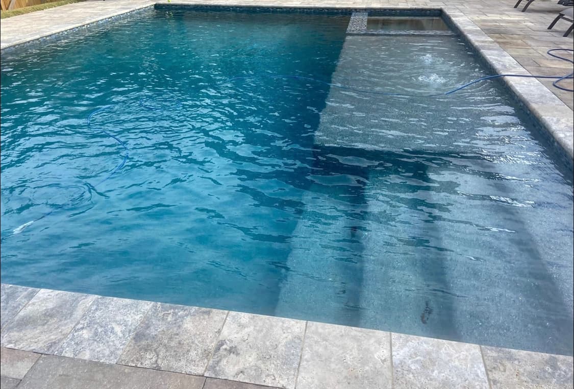 Pool with integrated in-water seating and entertaining layout.