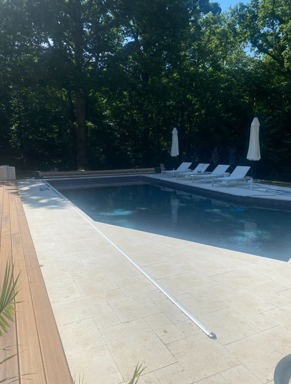 Rectangular pool with natural stone decking and clean hardscape lines.