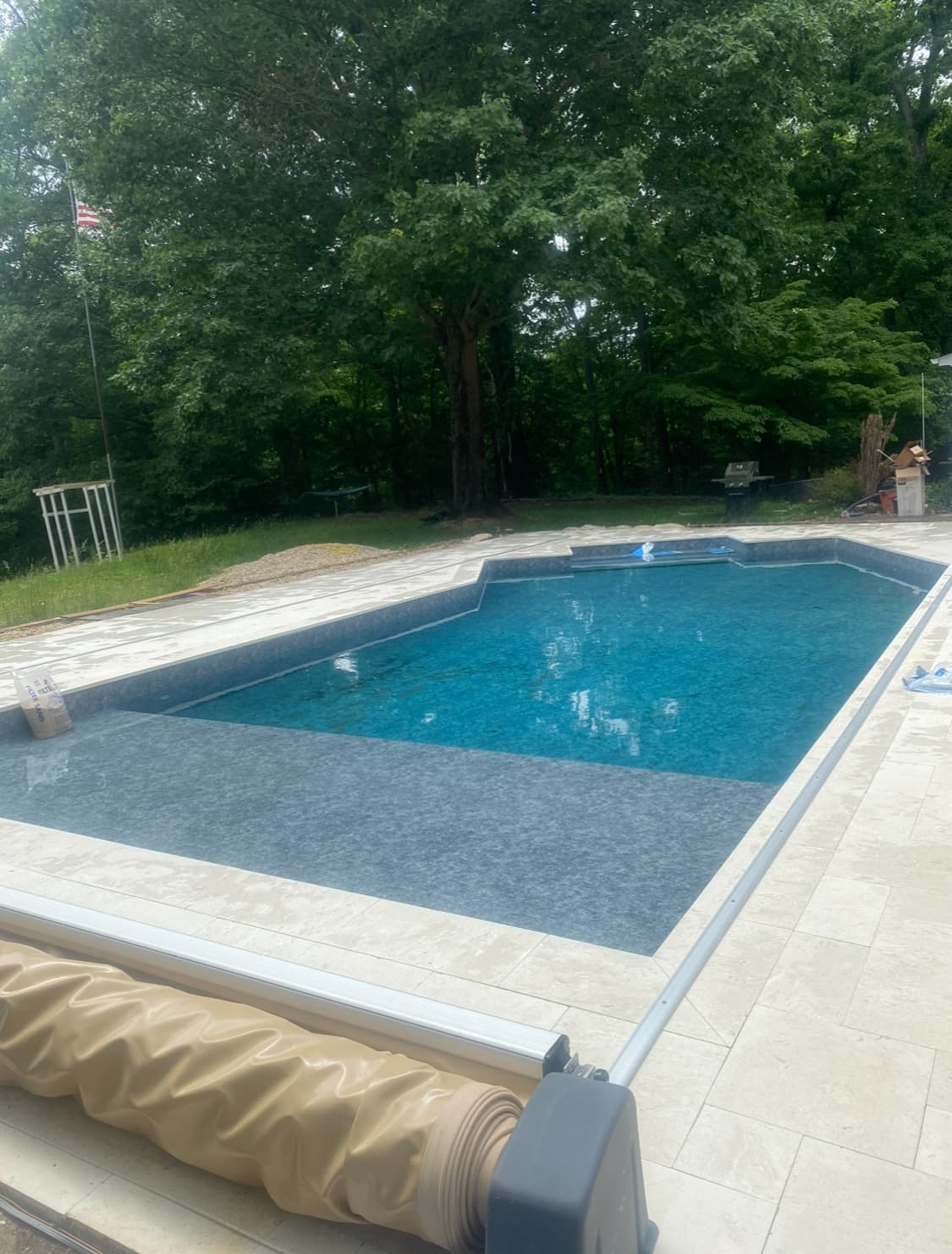 Finished gunite pool with stone coping and clean structural lines.
