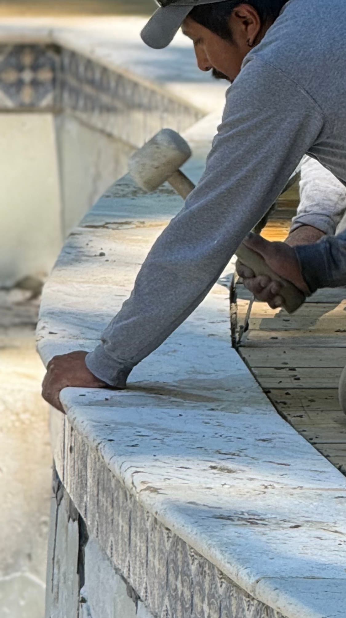 Pool and spa with clean coping lines and raised stone border.