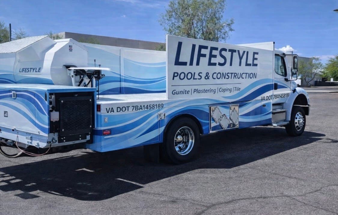 Lifestyle Pools & Construction branded equipment truck with full blue wave wrap.