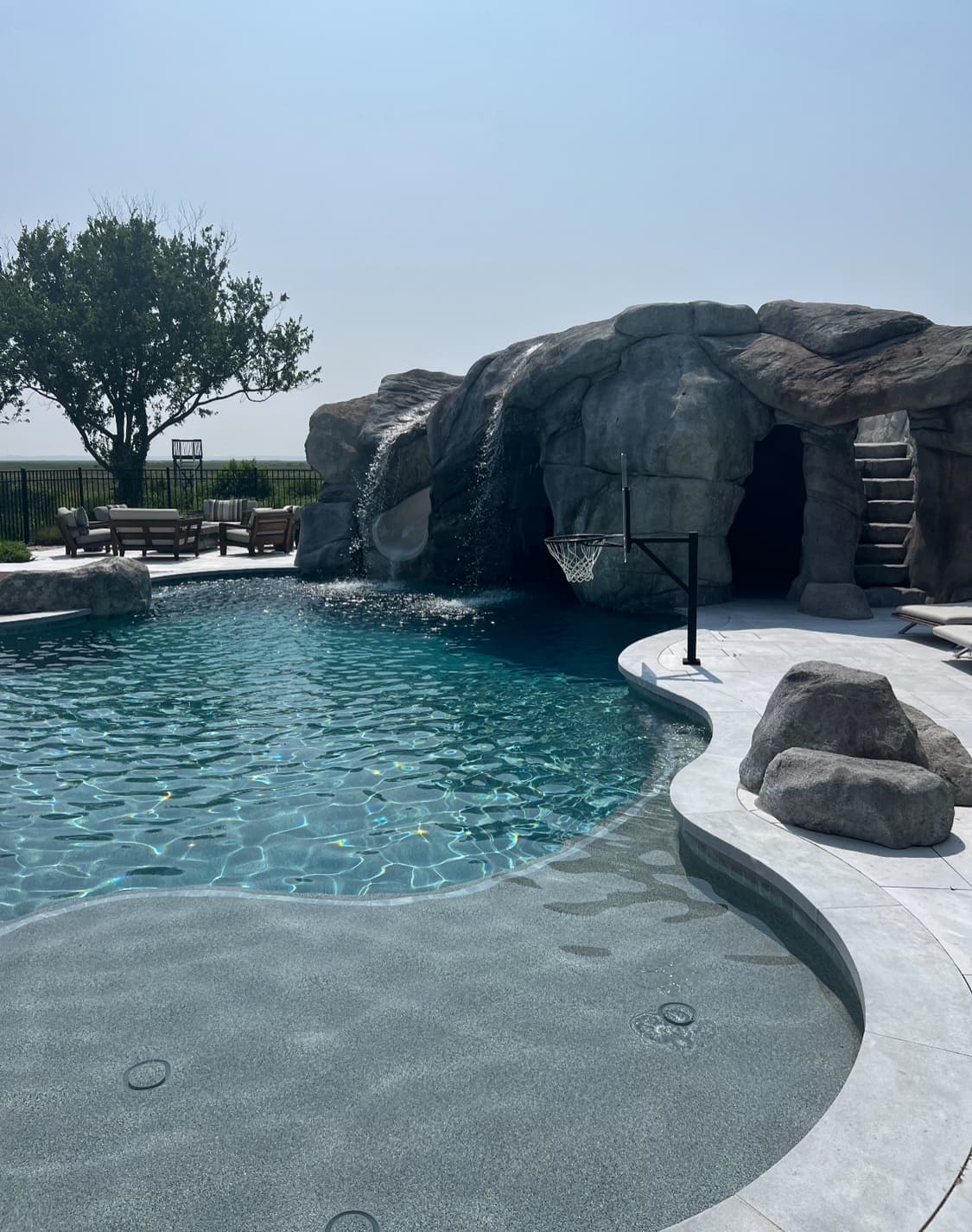 Custom pool and spa framed by premium hardscape at dusk.